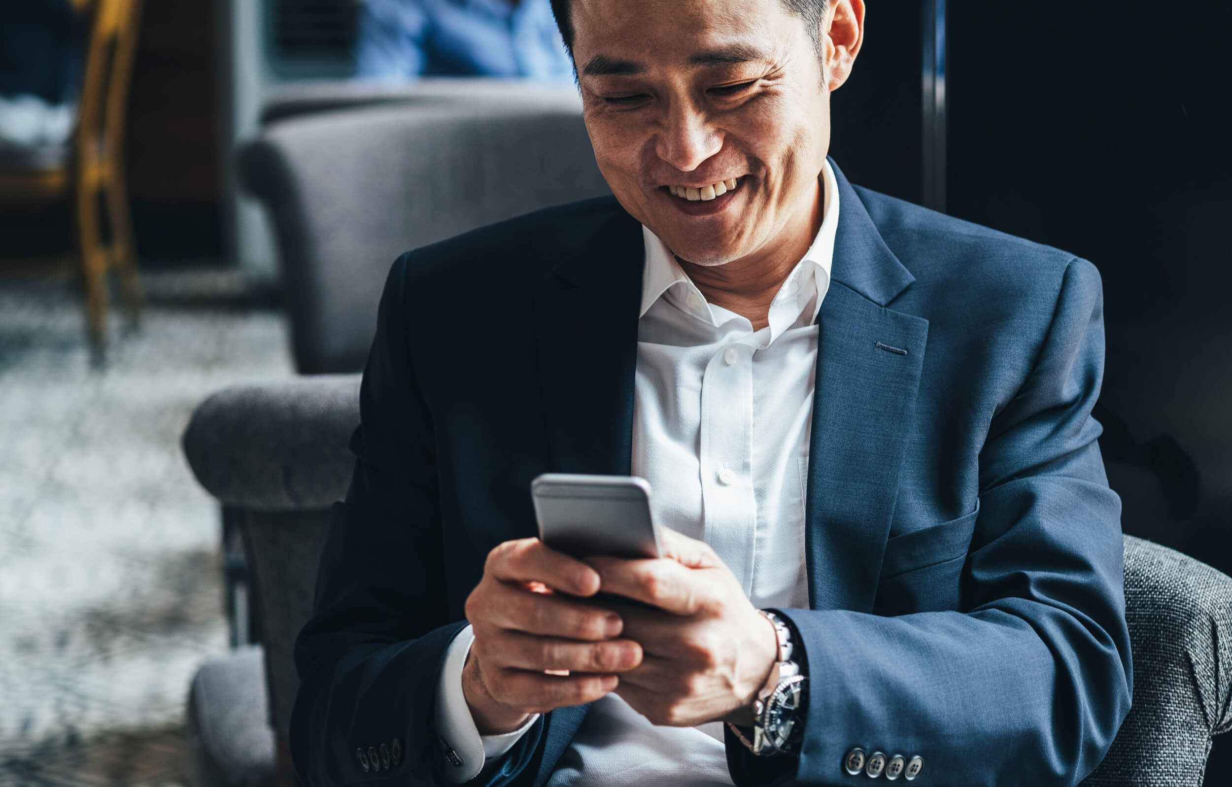 bien en nu propriete - homme en costume souriant sur son smartphone